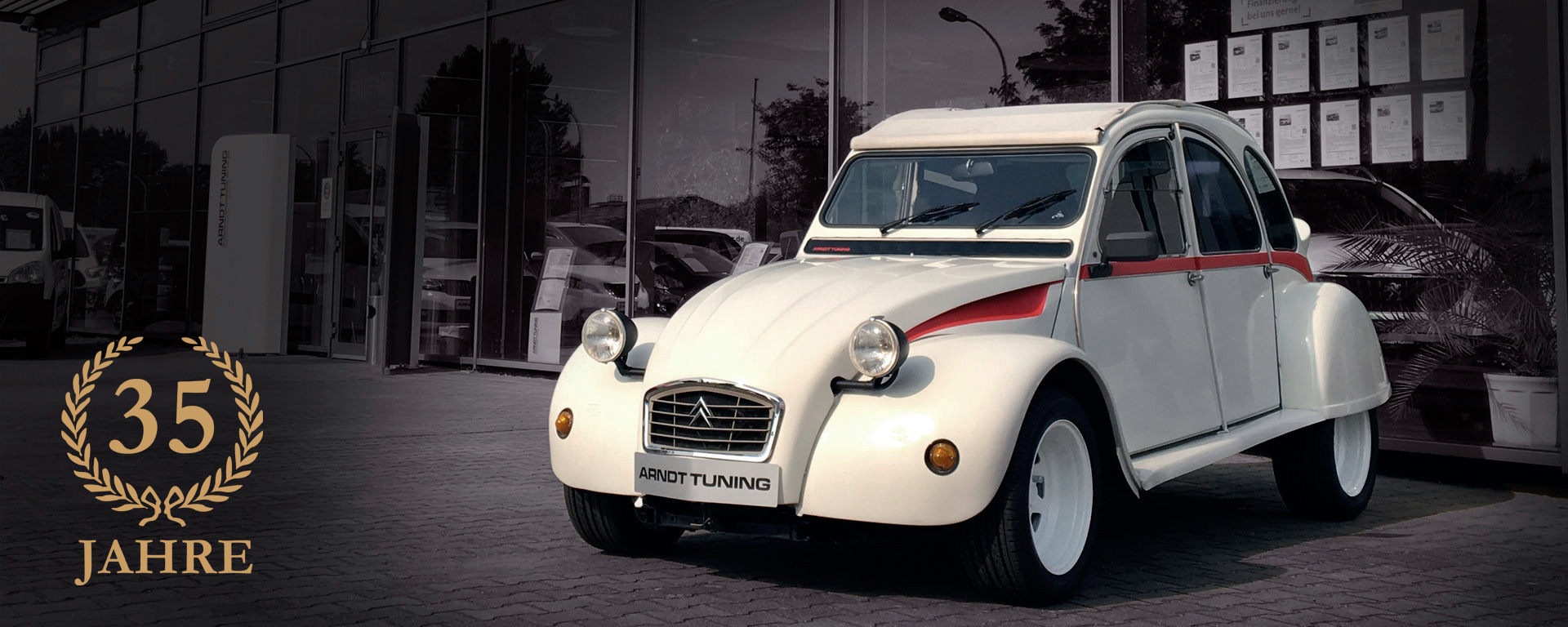 Citroën 2CV vor dem Arndt Tuning Showroom in Berlin – Jubiläumsfoto zum 35jährigen Bestehen des Autohauses