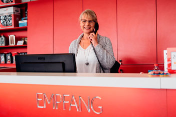 Empfang im Autohaus Arndt Tuning Berlin – freundliche Mitarbeiterin am Tresen für Kundenservice und Beratung