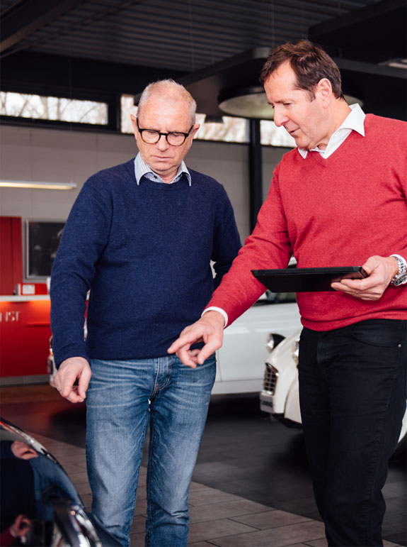 Autoankauf Beratung bei Arndt Tuning Berlin – Mitarbeiter erklärt Fahrzeugdetails einem Kunden im Showroom